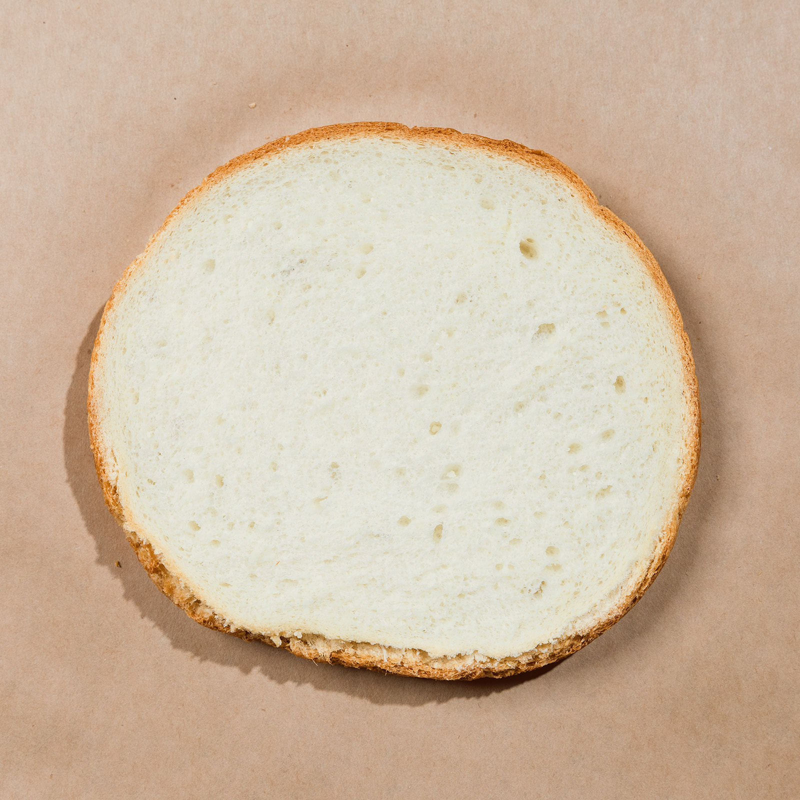Round cross-section slice of La Segunda sourdough bucket bread, pale tender crumb.